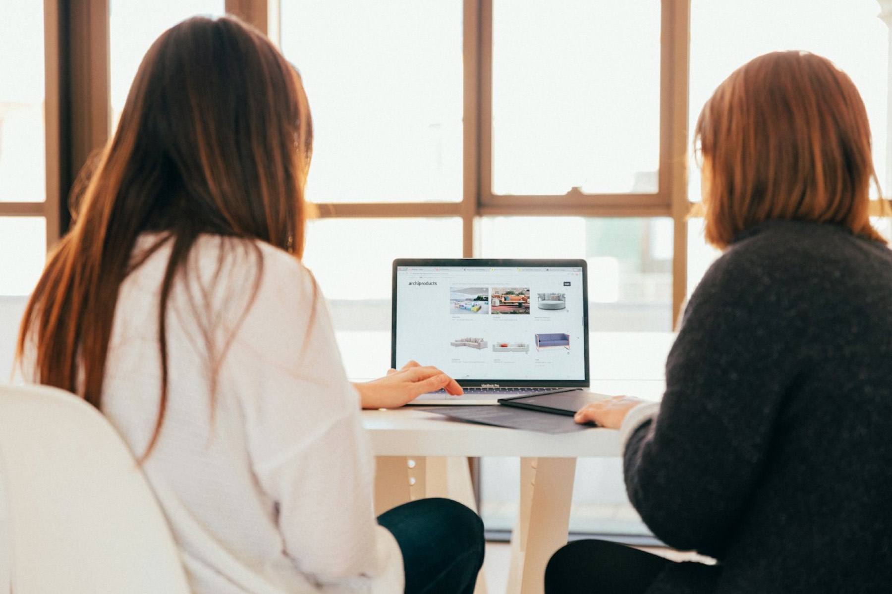 Zwei Frauen arbeiten gemeinsam am Laptop