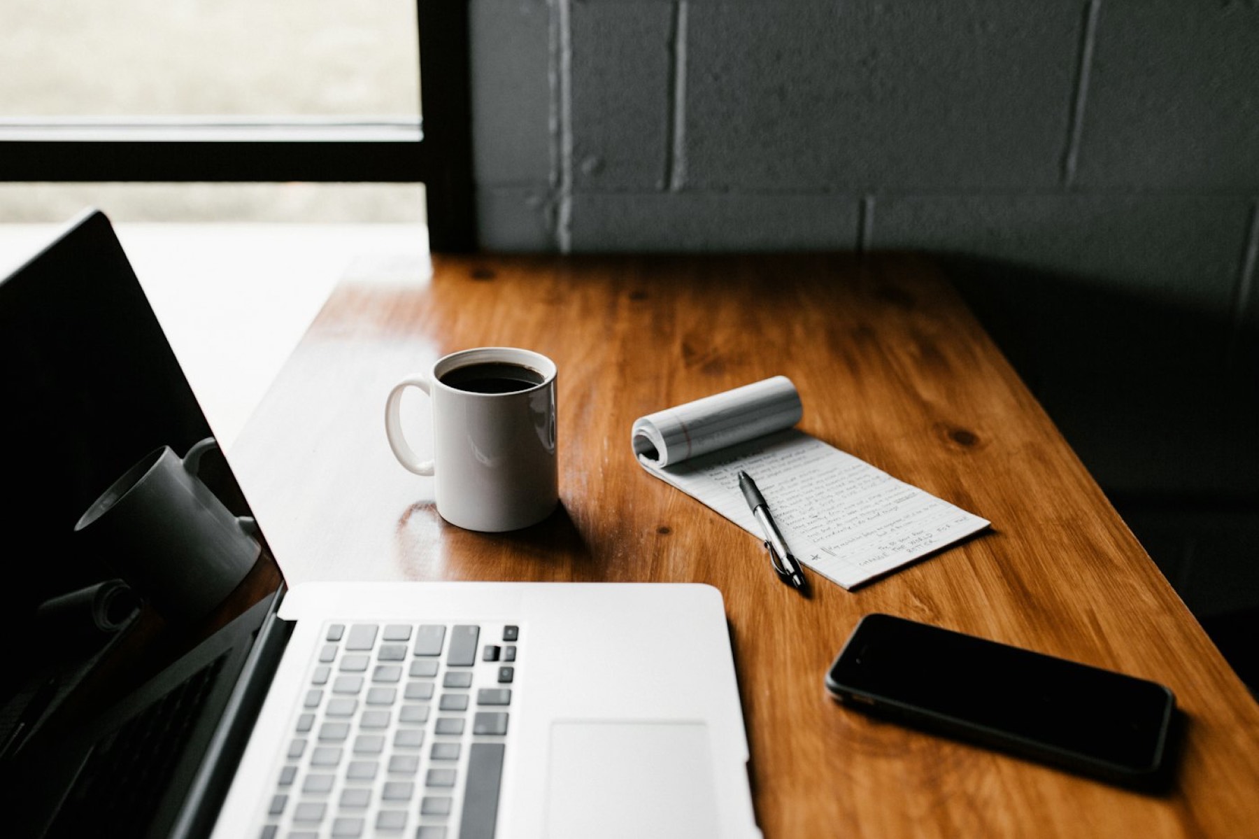 Aufgeräumter Arbeitsplatz mit Laptop und Kaffee